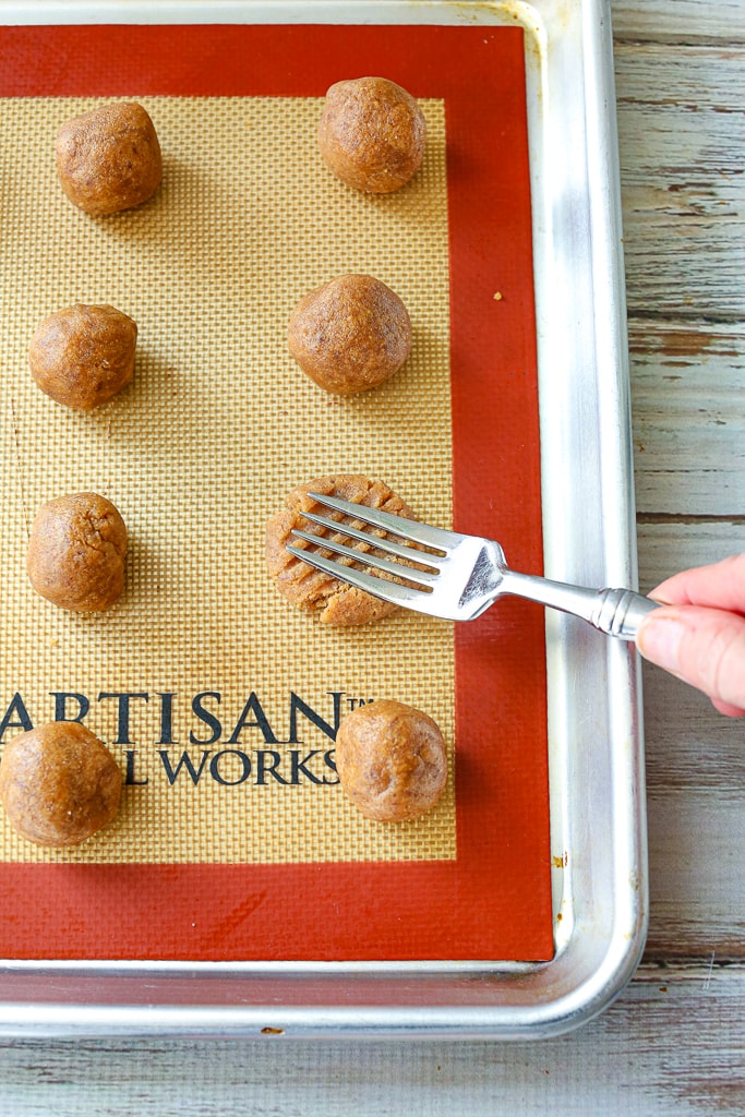 dough balls on a baking sheet with a fork 