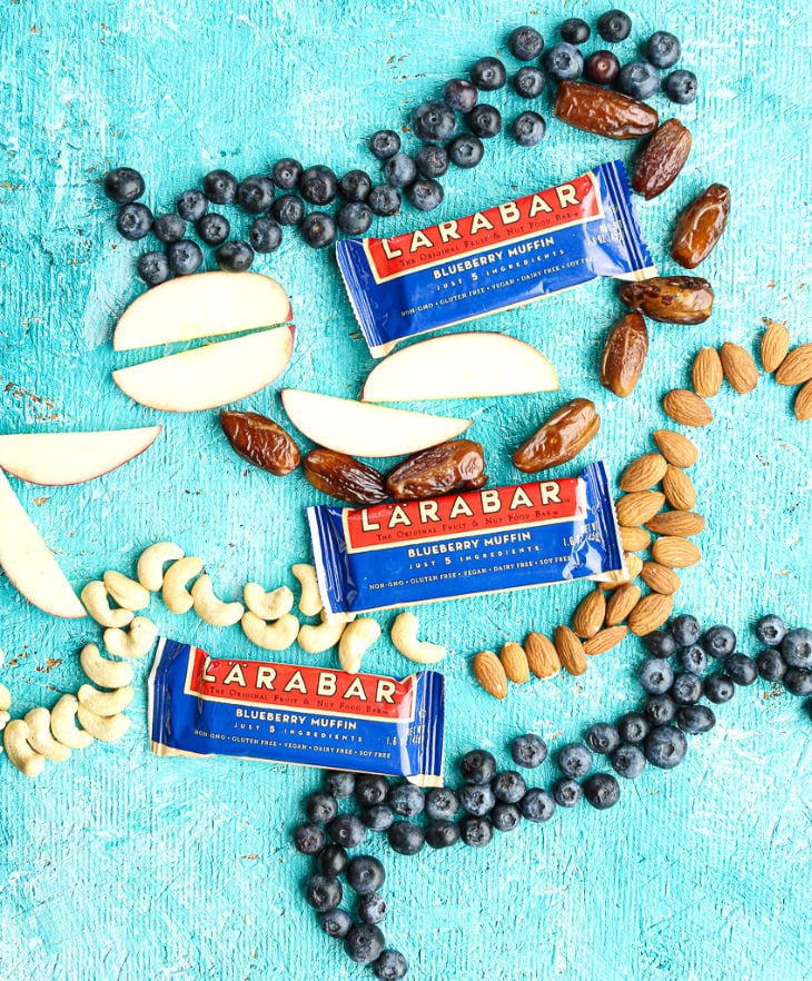 Three Blueberry Muffin Larabars with almonds dates apples, and blueberry surrounding them