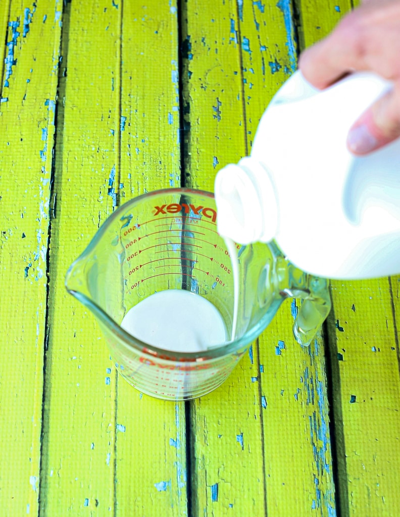pouring milk into a glass measuring cup