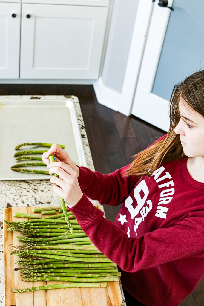 Meghan helping prepare the baked asparagus by bending and snapping off the ends.