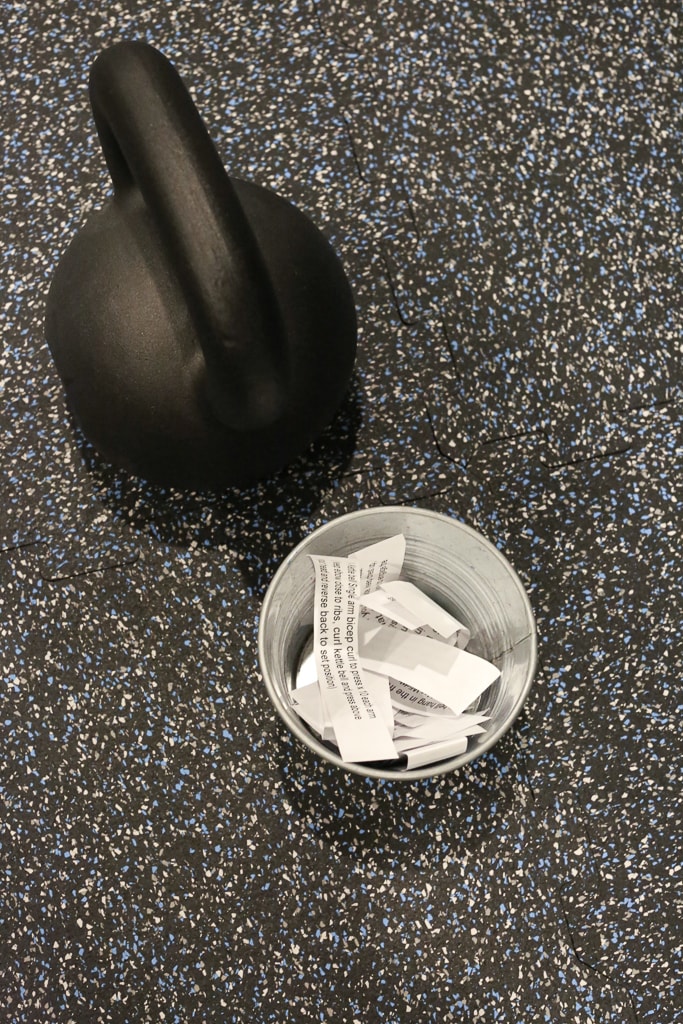 a container with papers and a kettlebell for the full body kettlebell workout