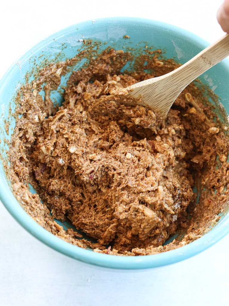 a thick batter in a turquoise bowl with a wooden spoon