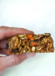 A bite taken out of a cookie with pieces of oats and carrot showing