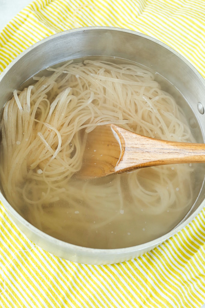 brown rice noodles soaking in a pan