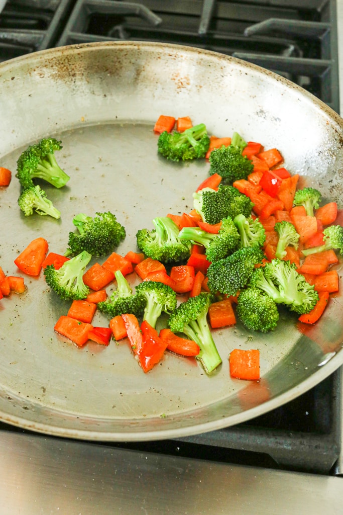 sauté broccoli and red bell peppers in a large skillet on the stovetop 