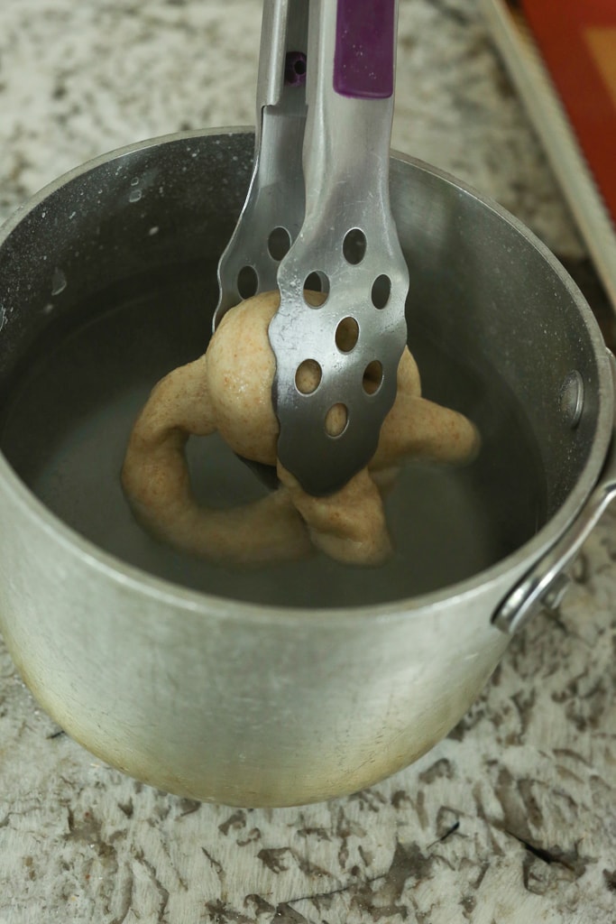 tongs removing the dough from the pan