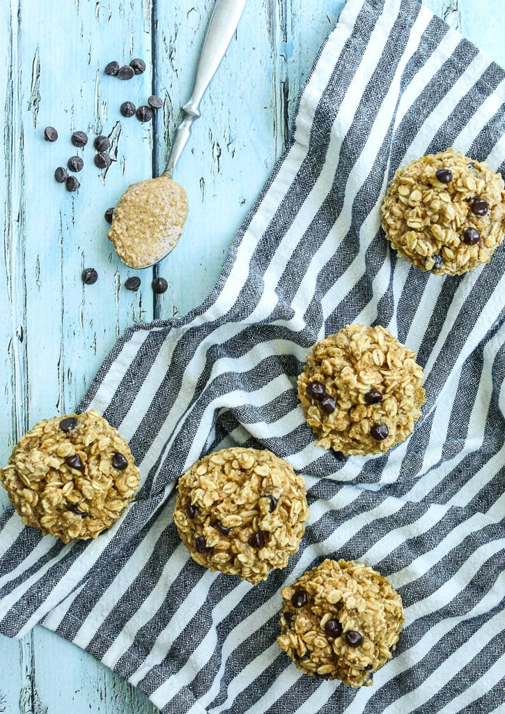 overhead shot of 5 Peanut Butter Chocolate Chip Baked Oatmeal Muffin Cups with a spoon of peanut butter and some chocolate chips 