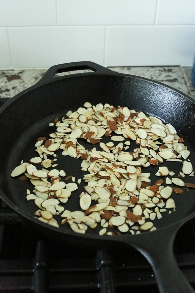 almond slices in a black cast iron skillet