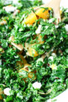 close up picture of easy kale salad being served with a serving spoon