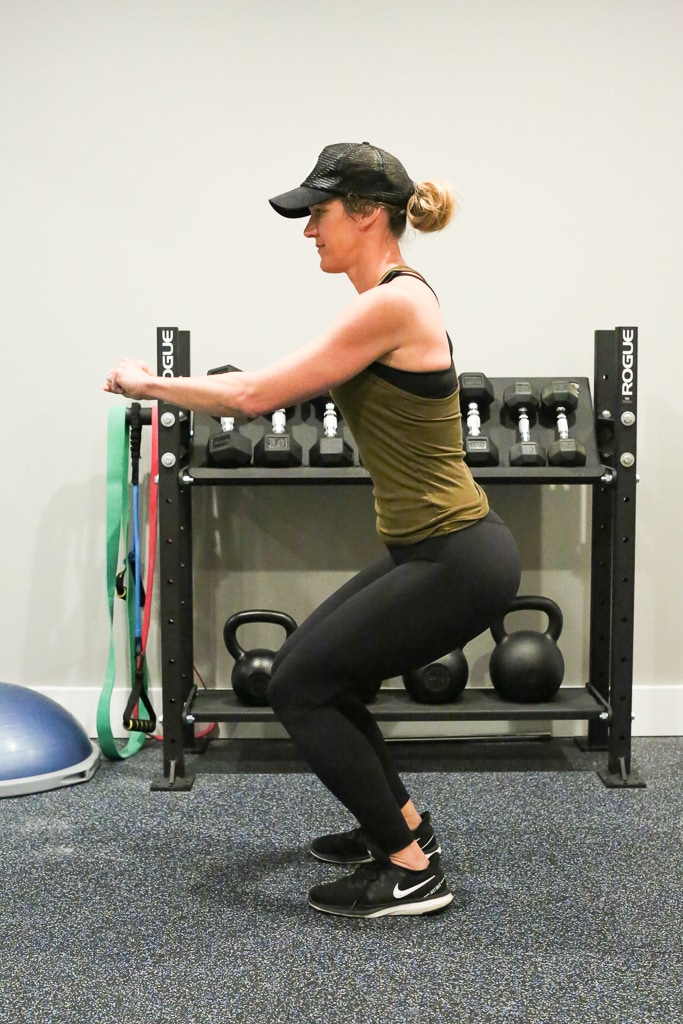 a woman doing squat with no weights