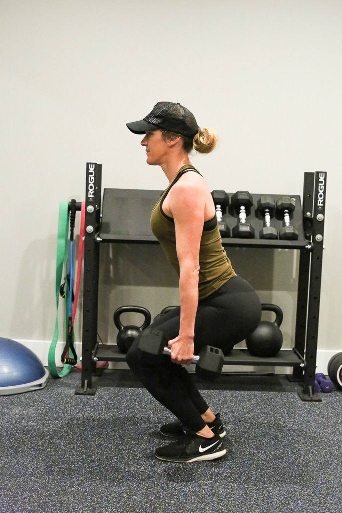 a woman doing a squat exercise with weights