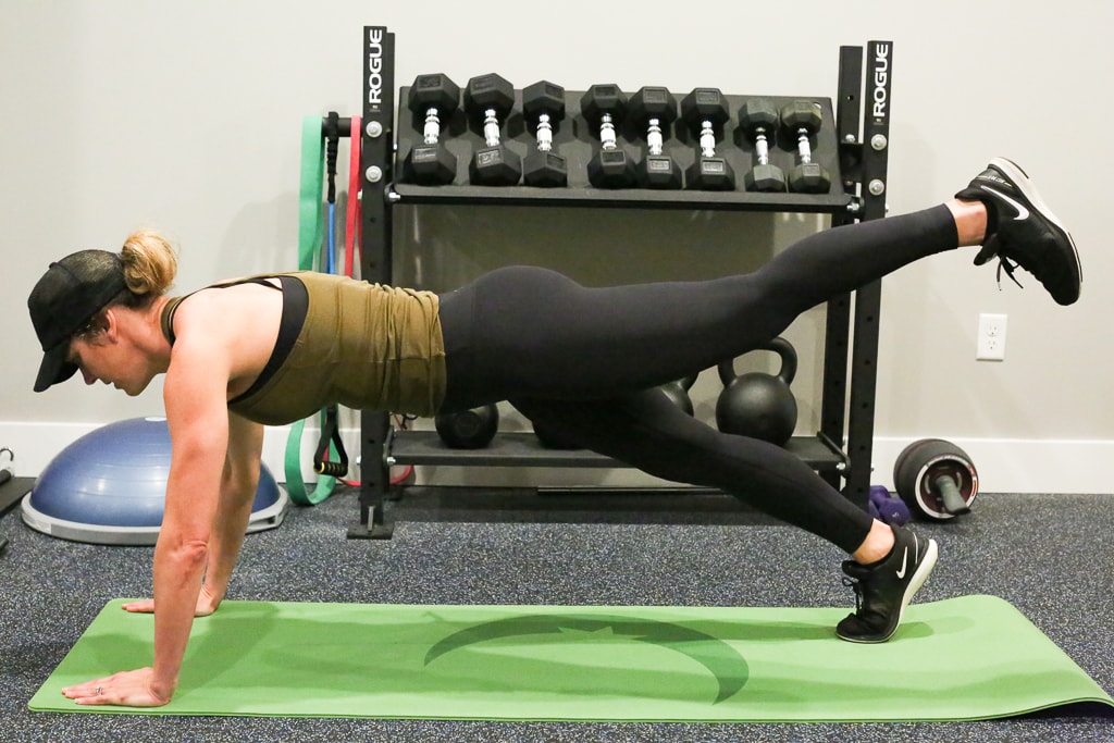 a woman performing high plank leg extension