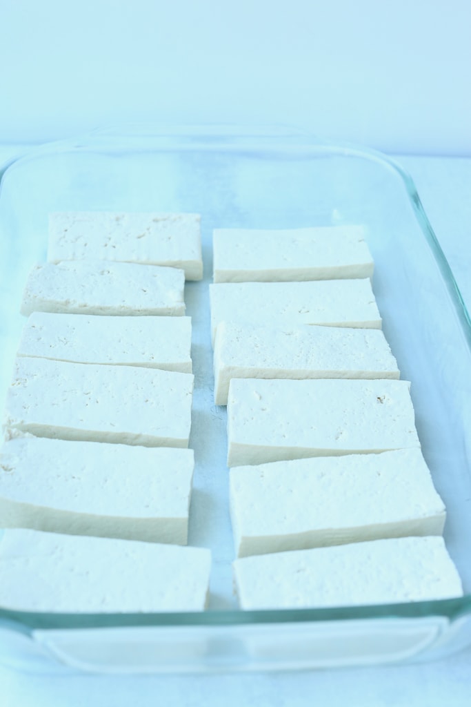 a shallow glass baking dish with 12 pieces of tofu