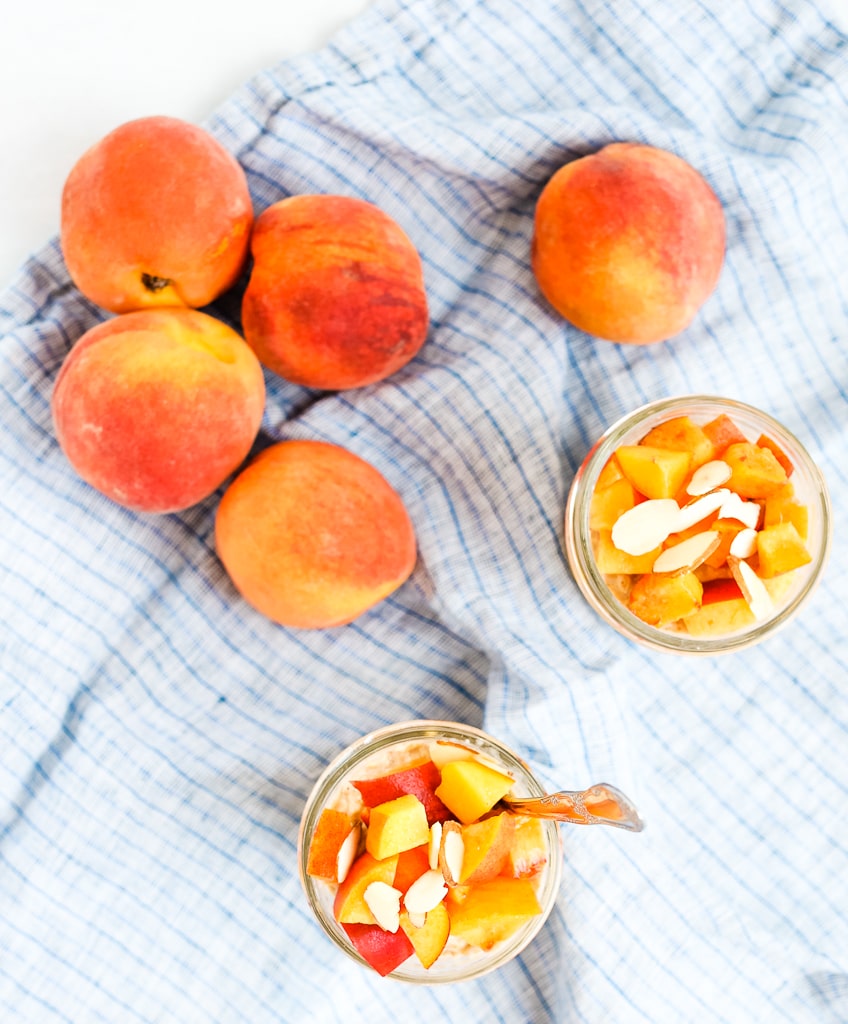 overhead shot of two mason jars filled with diced peaches and sliced almonds