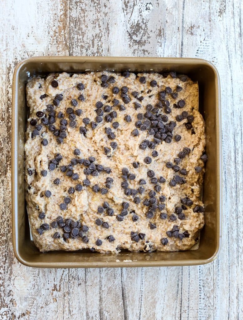 A square baking pan with raw batter of Healthy Banana Chocolate chip dessert bars before baking