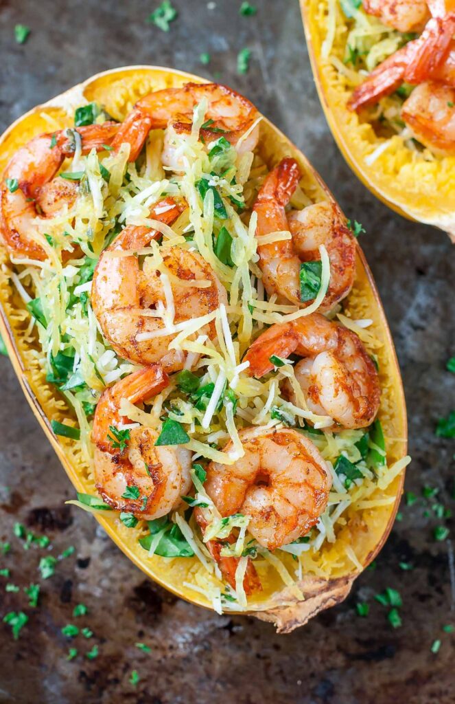 An overhead shot of half of a spaghetti squash shell with shrimp and cheese
