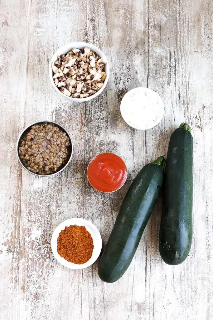 recipe ingredients on a board--zucchini, lentils, onion, tomato sauce, taco seasoning 
