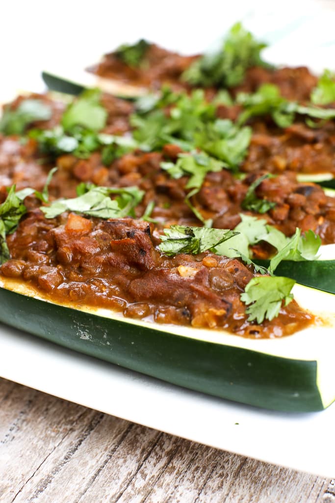 close up picture of a zucchini boat stuffed with a taco lentil mixture and topped with cilantro
