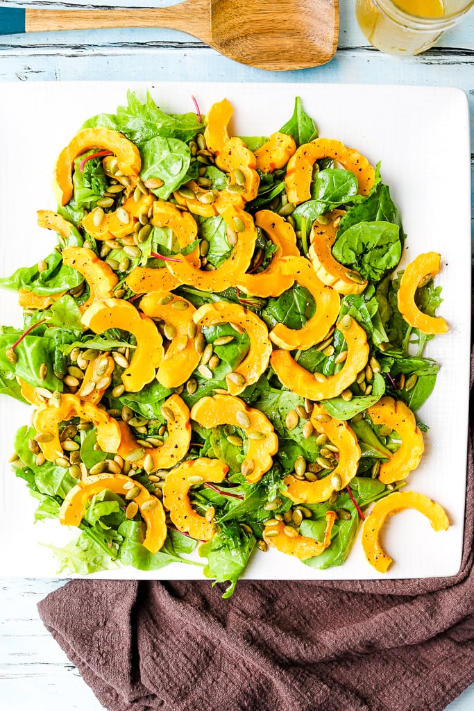an overhead shot of roasted deletica squash salad on a white plate