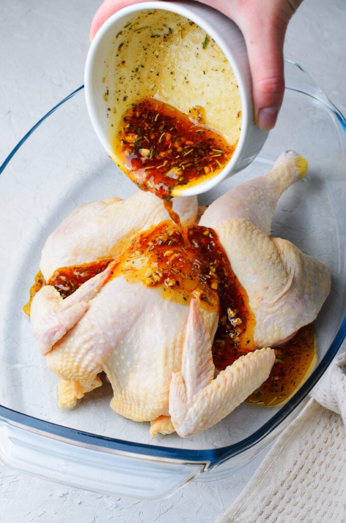 pouring the marinade on raw chicken