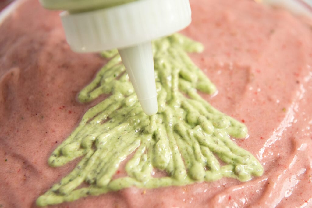 decorating the top of a smoothie bowl with a squeeze bottle