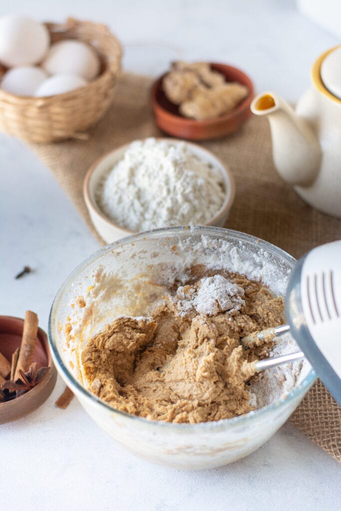 adding the flour to the butter, eggs, and sugar