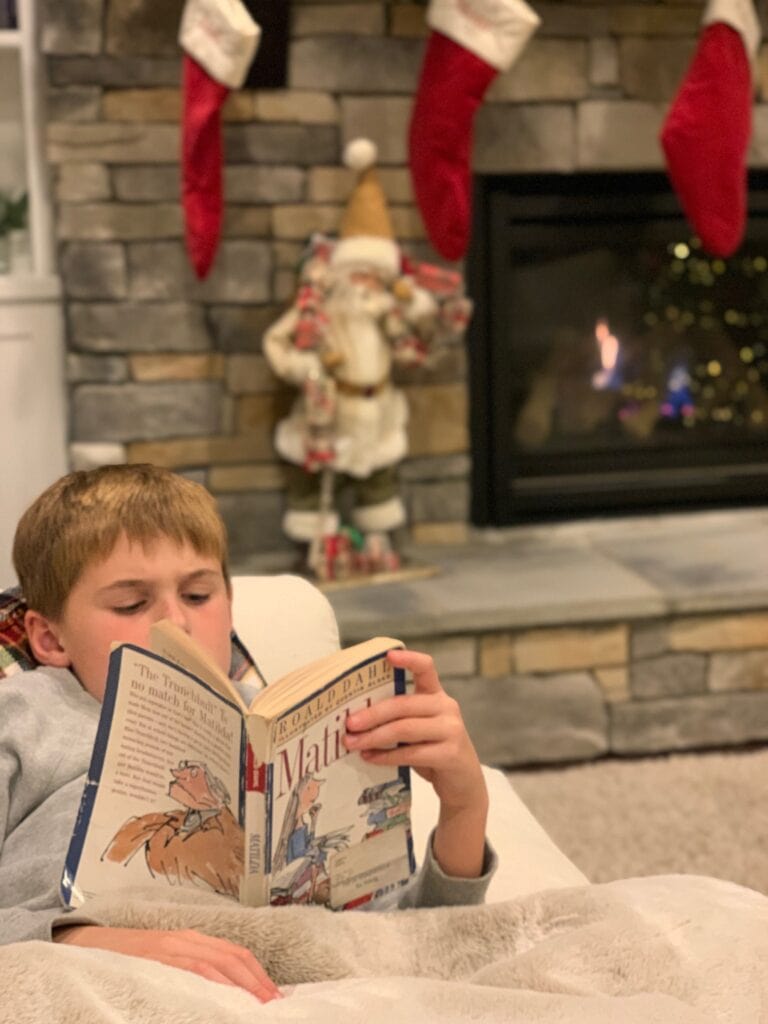 Luke laying on the couch reading Matilda
