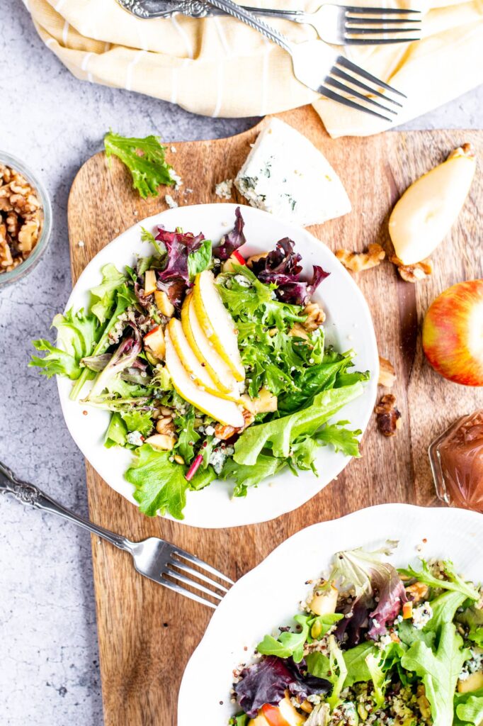 overhead shot of a green salad with sliced pears