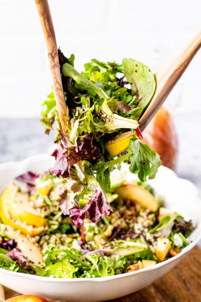 Pear Gorgonzola Salad in a bowl being scooped up and served