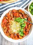 overhead shot of vegetarian chili with cheese and cilantro on top