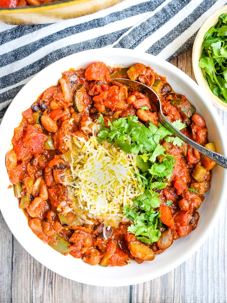 overhead shot of vegetarian chili with cheese and cilantro on top