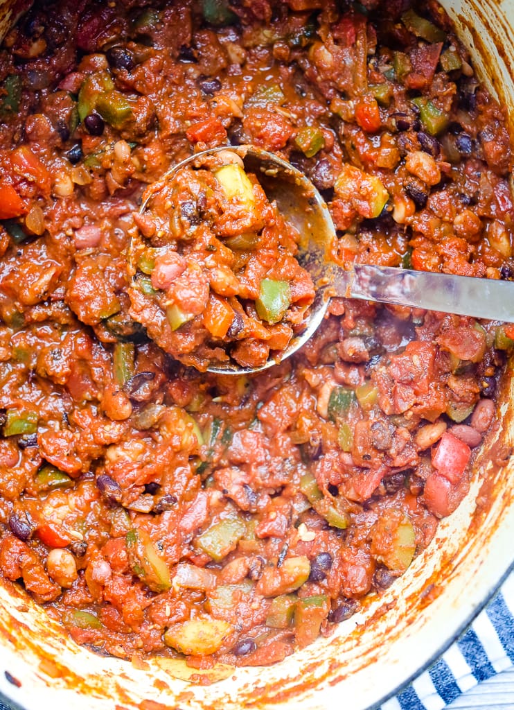 close up shot of chili being spooned out of a big pot