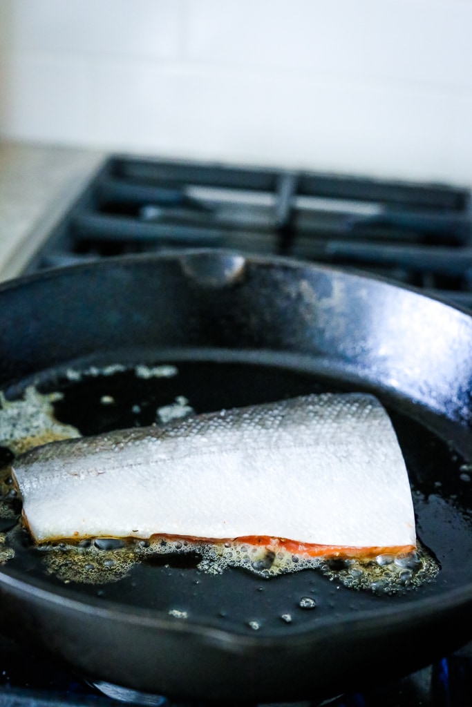 a filet of salmon in a skillet skin side up