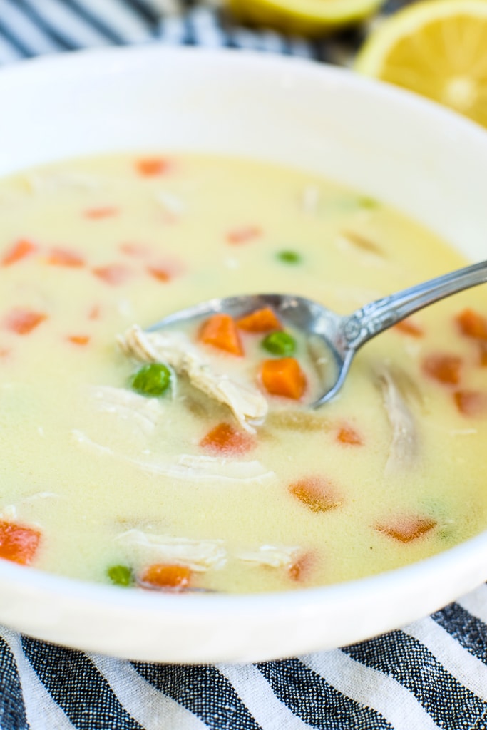 a spoonful of Greek Lemon Chicken soup coming out of bowl