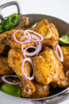 a pan ful of tandoori chicken with red onions