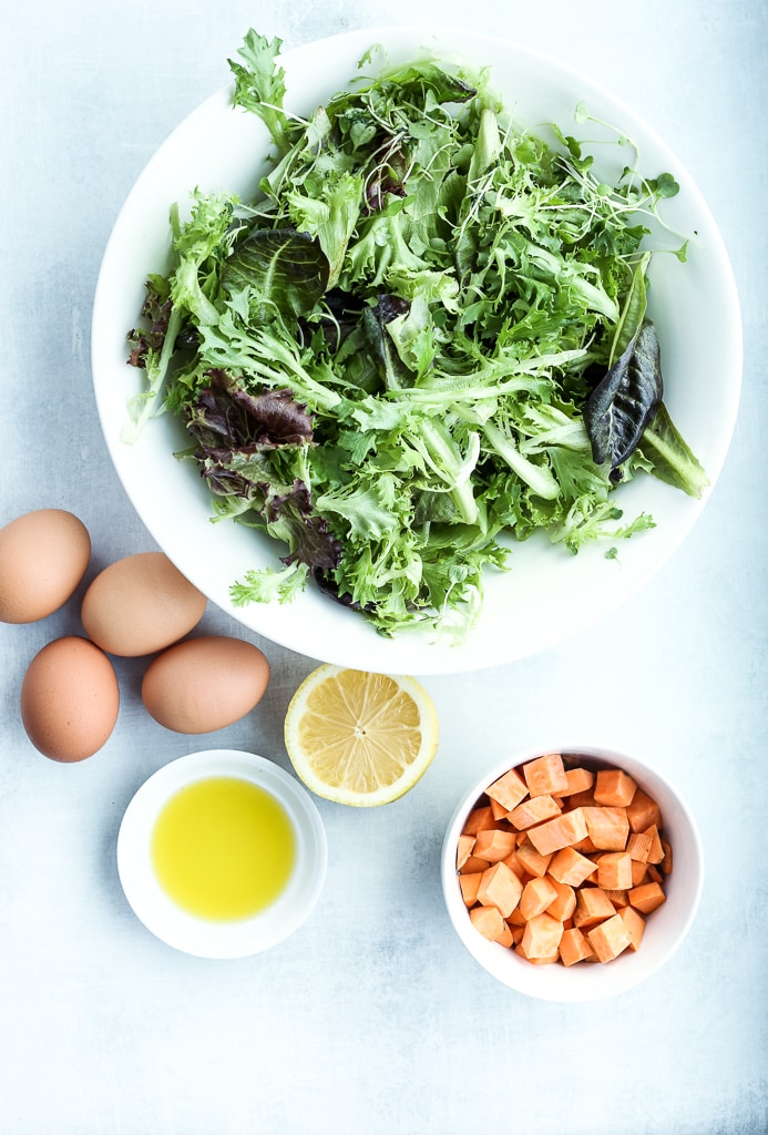 ingredients for breakfast salad--greens, eggs, lemon, sweet potato and oil