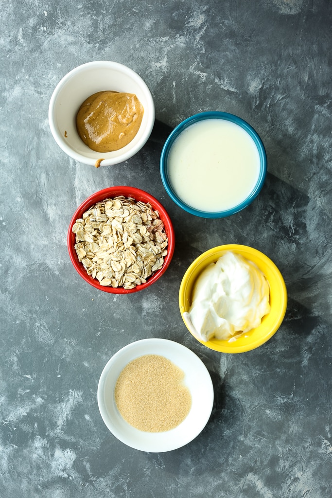 overhead shot of recipe ingredients--oats, Greek yogurt, golden monkfruit sweetener milk, and peanut butter