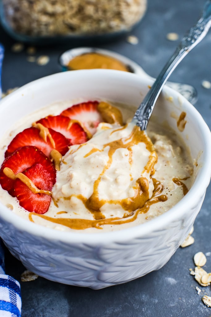 a close shot of Peanut Butter Overnight Oats recipe with strawberries on top and extra peanut butter