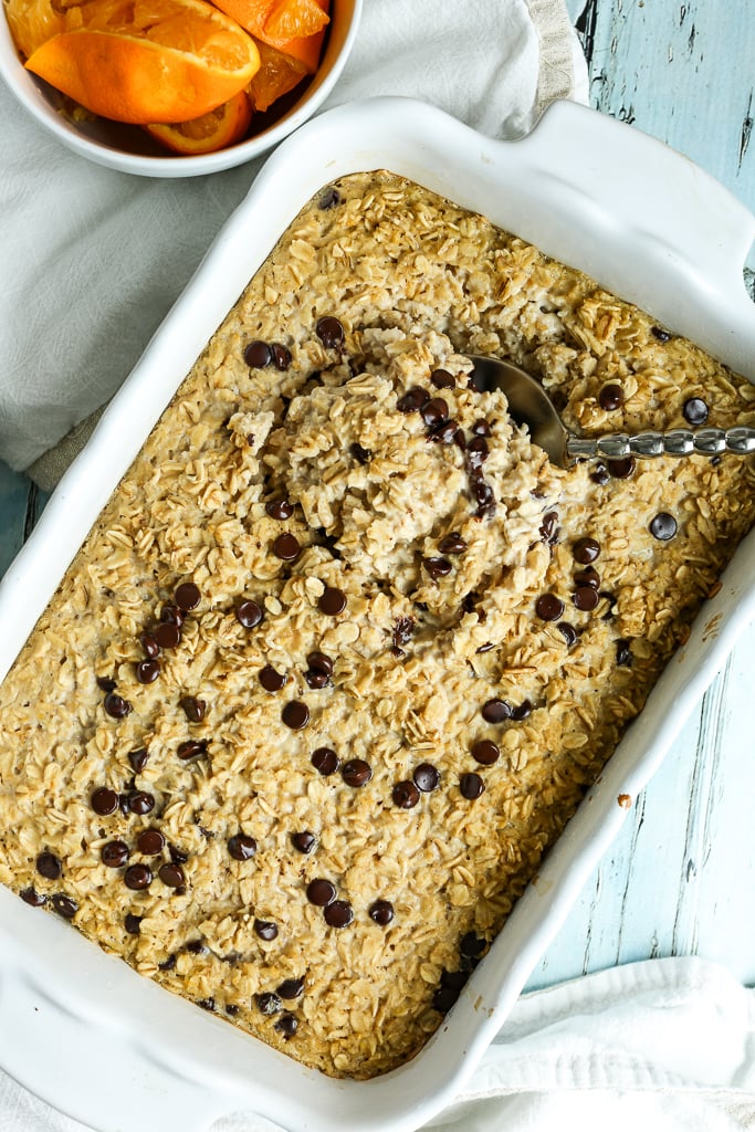 Orange Chocolate Chip Baked Oatmeal in a white baking dish with a spoon overhead shot