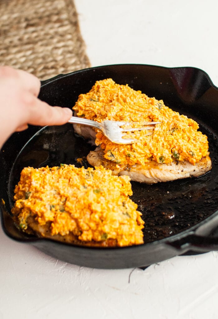 pressing the buffalo cheese mixture onto the chicken breast