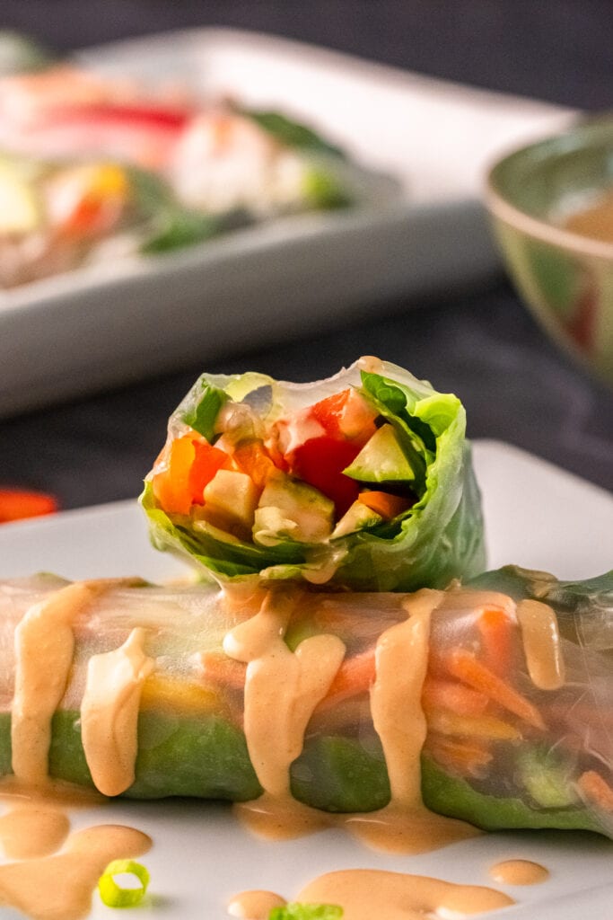 Vegan Spring Rolls Recipe one cut in half stacked on another with peanut sauce
