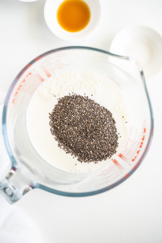 chia seeds in a glass measuring cup with milk