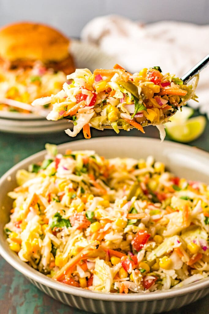 serving with a spoon and a BBQ sandwich in the background
