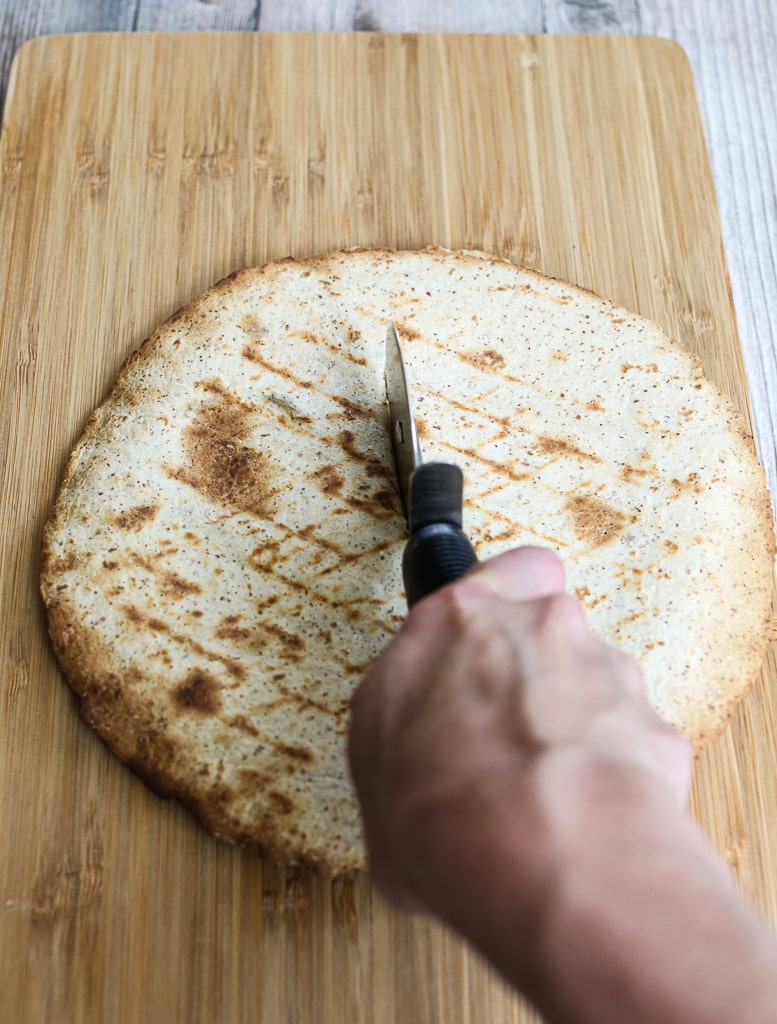 slicing the Grilled Zucchini Quesadilla with a pizza cutter