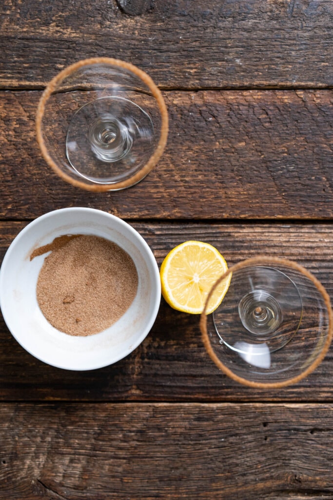 adding cinnamon sugar to the rim of two cocktail glasses