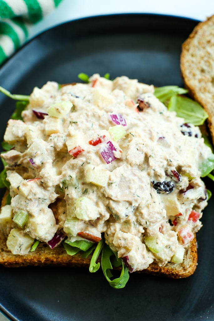 an open faced sandwich with apple cranberry tuna salad