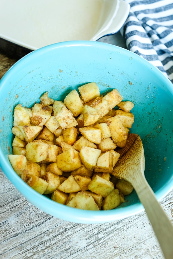 chopped apples in a blue bowl with spices