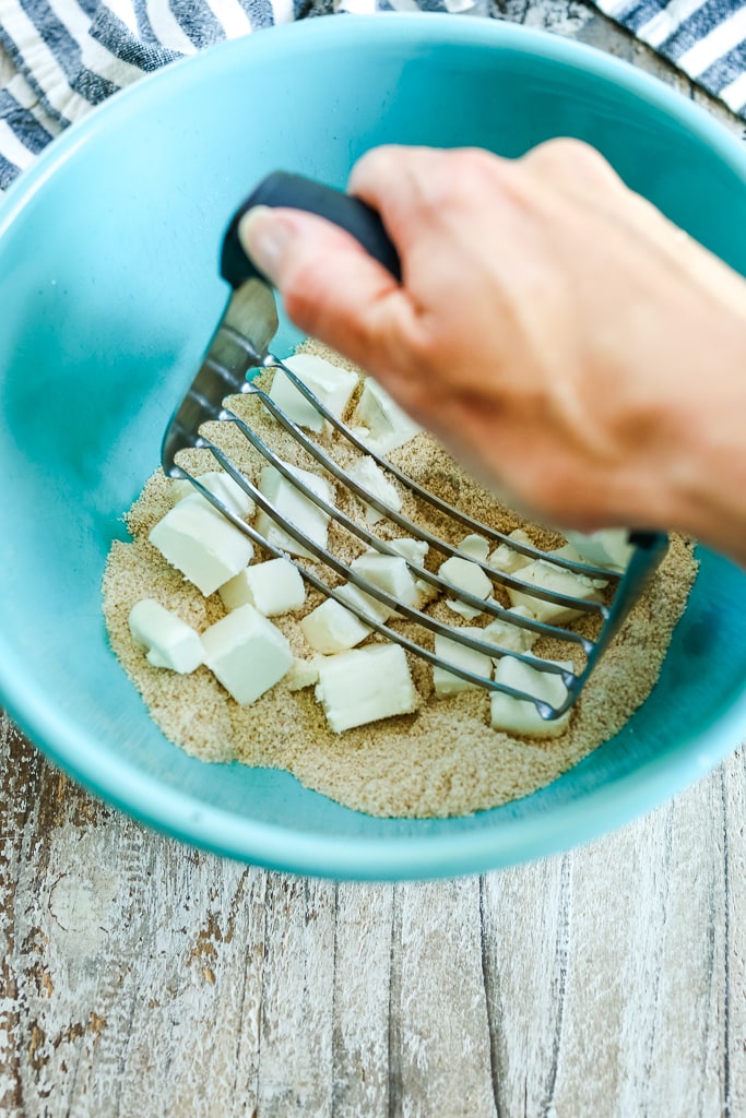 a pastry cutter cutting butter into ingredients