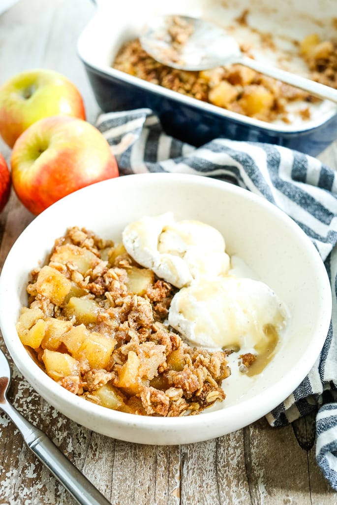 apple crisp in a bowl with ice cream 