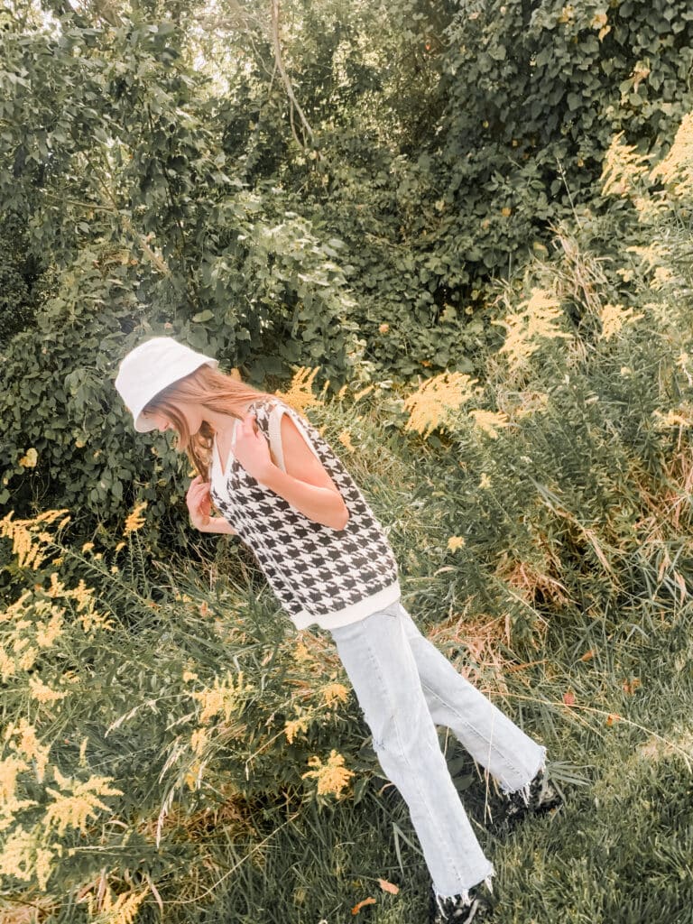 a young girl walking by yellow flowers in grass